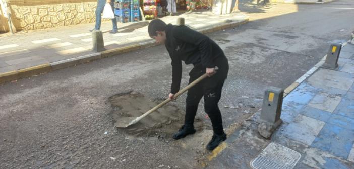 Esnaf, yoldaki çukurları kendisi doldurdu